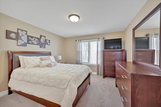 bedroom with light colored carpet and baseboards