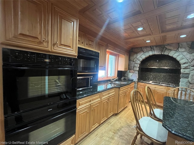 3015 E Village Ln, Port Huron, MI 48060 - kitchen featuring light wood finished floors, dark stone countertops, black appliances, a sink, and tasteful backsplash