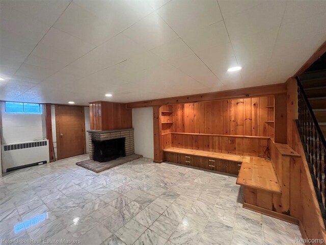 3015 E Village Ln, Port Huron, MI 48060 - unfurnished living room featuring radiator heating unit, stairway, a brick fireplace, wooden walls, and recessed lighting
