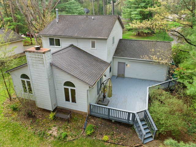 rear view of house with a shingled roof and a deck
