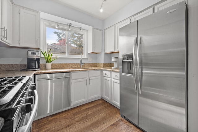 kitchen with a sink, white cabinets, and stainless steel appliances