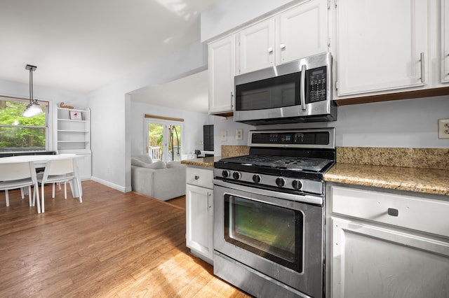 kitchen with white cabinetry, light wood finished floors, a wealth of natural light, and stainless steel appliances
