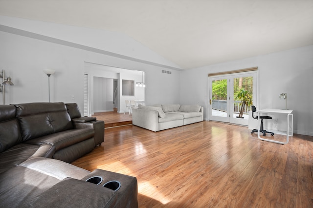 living room featuring visible vents, wood finished floors, and vaulted ceiling