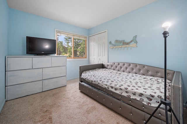 carpeted bedroom with baseboards and a closet