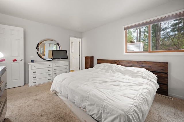 bedroom featuring baseboards, light colored carpet, and visible vents