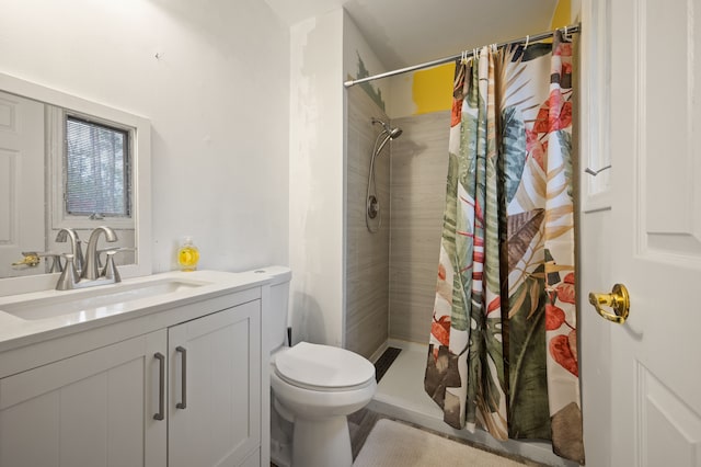 bathroom with vanity, a shower stall, and toilet