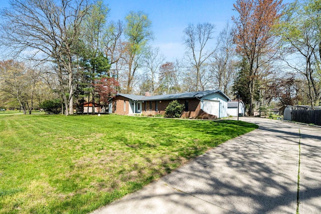 view of front of home featuring an attached garage, concrete driveway, brick siding, and a front yard