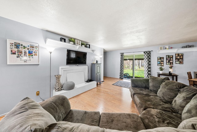 living area featuring light wood-type flooring and a textured ceiling