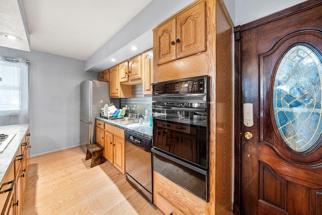 kitchen with decorative backsplash, dishwasher, oven, light wood finished floors, and a warming drawer