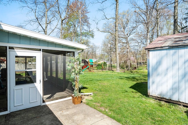 view of yard featuring a playground, an outdoor structure, a sunroom, and a storage shed