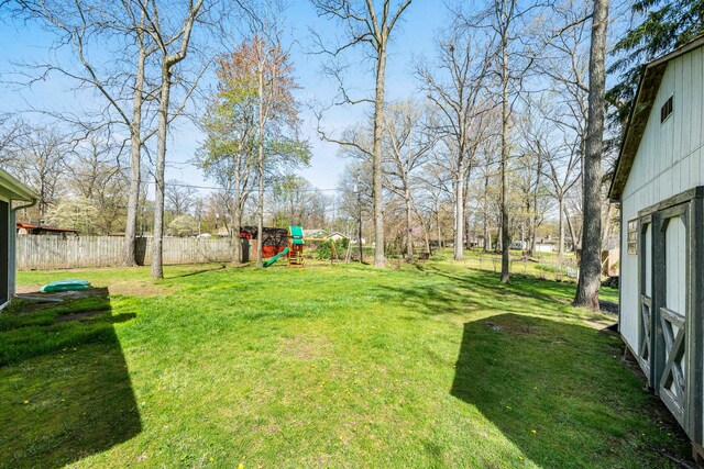 view of yard featuring fence and a playground