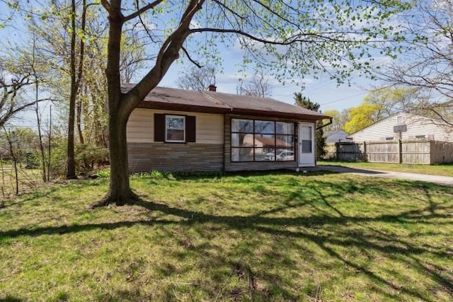 back of house with a lawn and fence