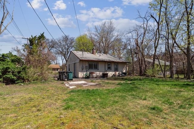 rear view of property with a lawn and a chimney