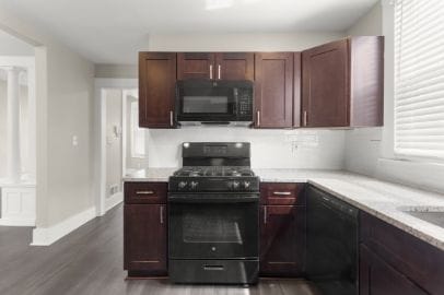 kitchen featuring baseboards, dark wood-style flooring, and black appliances