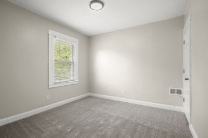 carpeted empty room with baseboards and visible vents