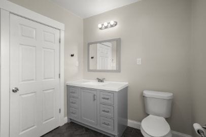 half bathroom featuring vanity, baseboards, and toilet