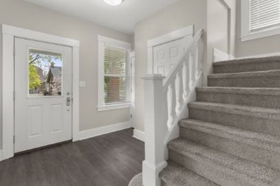 entrance foyer featuring baseboards, wood finished floors, and stairway