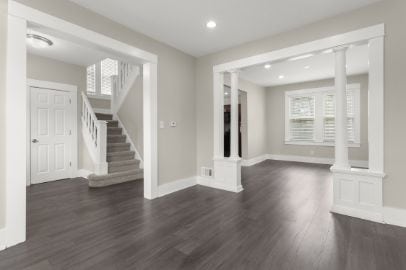 unfurnished living room featuring recessed lighting, baseboards, wood finished floors, and stairway