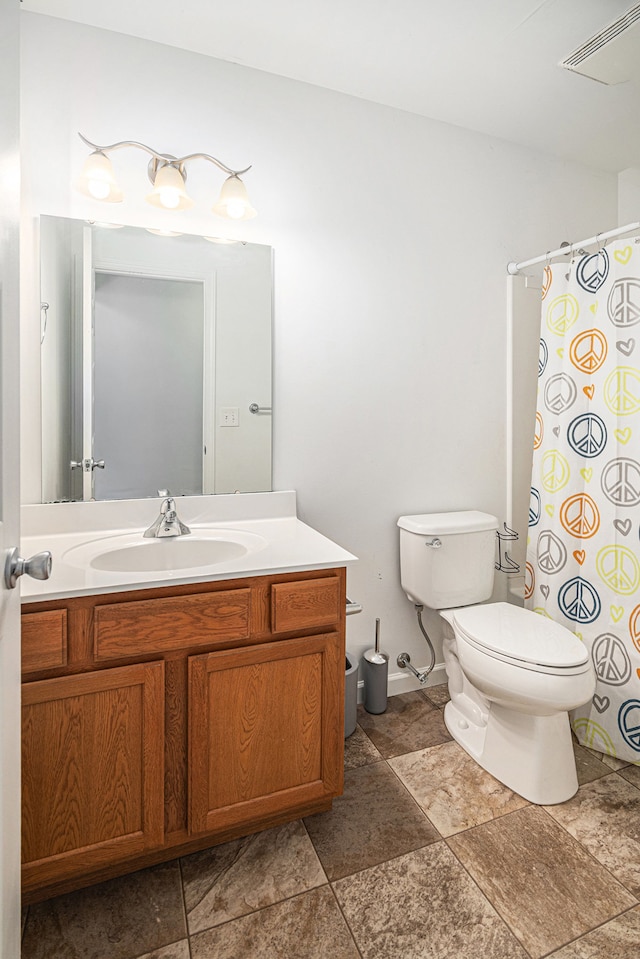 823 Glenlivet St, Howell, MI 48843 - bathroom with toilet, vanity, a shower with curtain, stone finish flooring, and baseboards