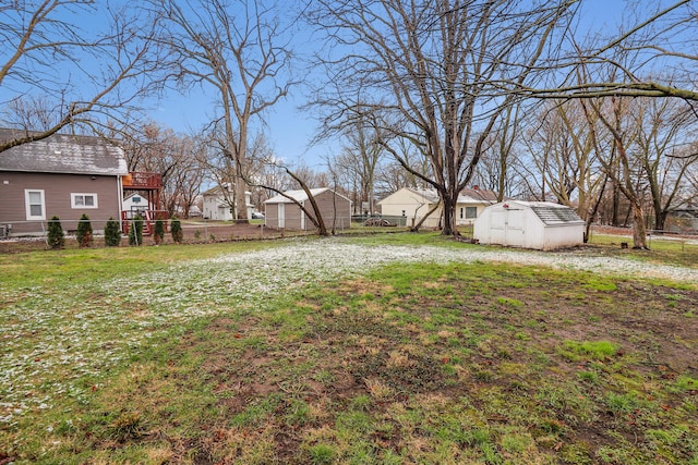 view of yard with fence, an outbuilding, and a shed