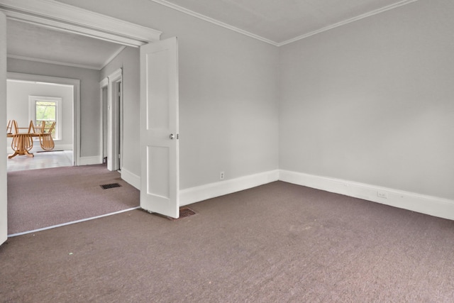carpeted empty room with baseboards, visible vents, and ornamental molding