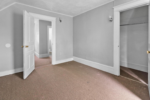 unfurnished bedroom with a textured ceiling, baseboards, a closet, ornamental molding, and carpet