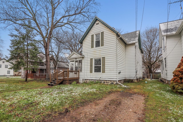 back of property with roof with shingles, a yard, and a deck