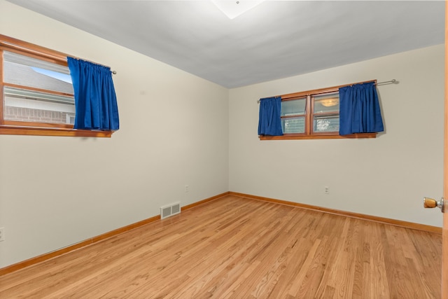 unfurnished room with light wood-type flooring, baseboards, and healthy amount of natural light