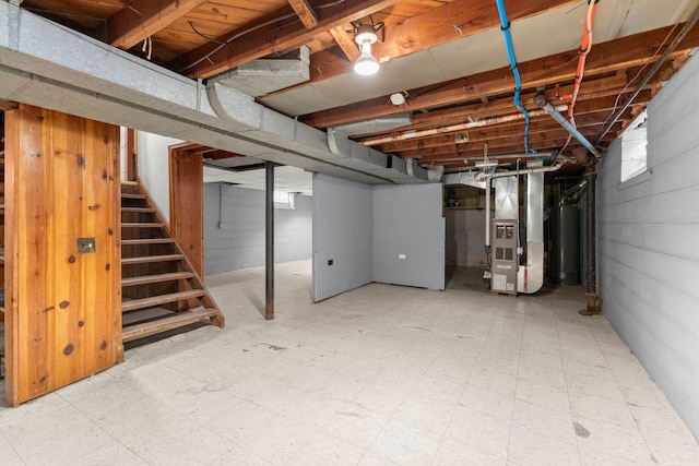 below grade area with heating unit, stairway, water heater, and tile patterned floors