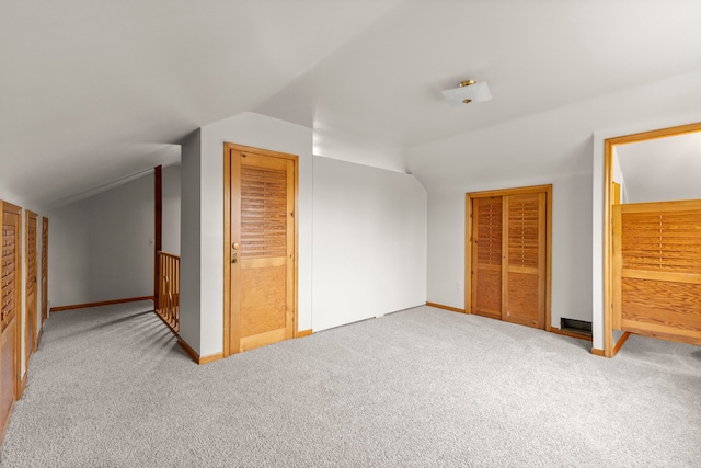 bonus room featuring vaulted ceiling, light carpet, and baseboards