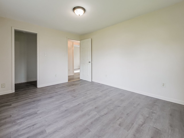empty room with baseboards and wood finished floors