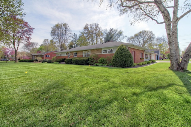 view of front of home with a front yard and brick siding