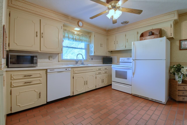 kitchen featuring white appliances, a sink, brick floor, and light countertops