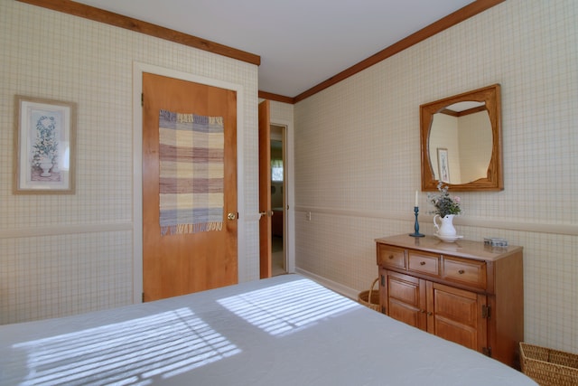 bedroom with ornamental molding and wallpapered walls