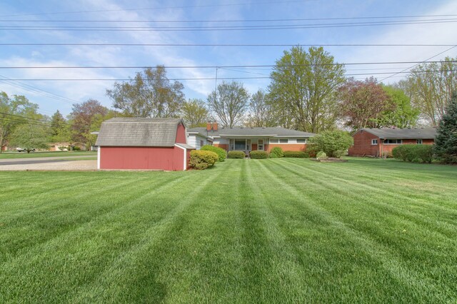 view of yard featuring a storage shed and an outbuilding