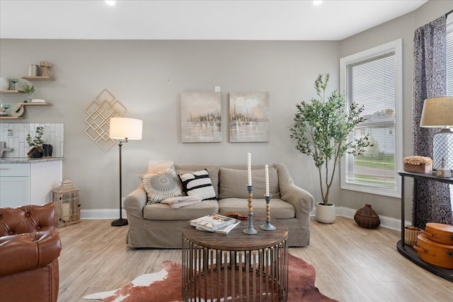 living room with baseboards, plenty of natural light, and light wood finished floors