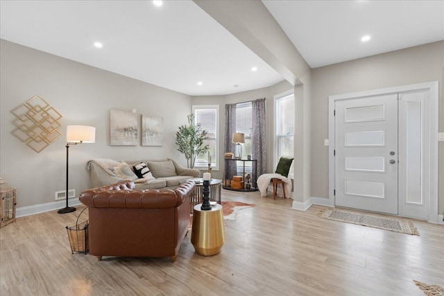 living area with baseboards, recessed lighting, and light wood-style flooring