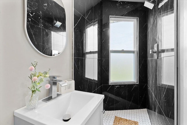 bathroom featuring a tile shower, a wealth of natural light, and vanity