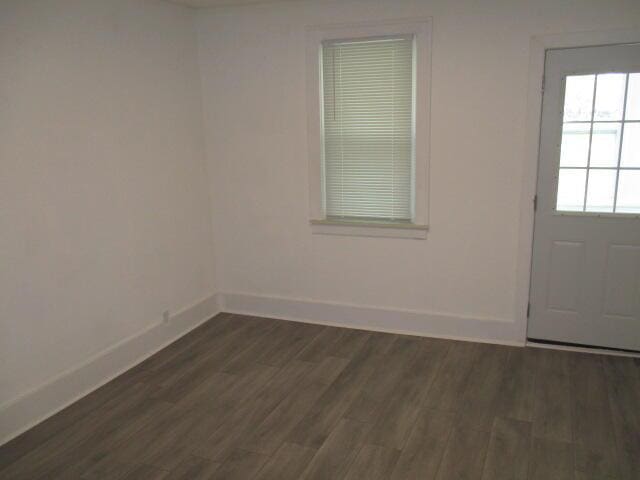 interior space featuring dark wood-style flooring and baseboards