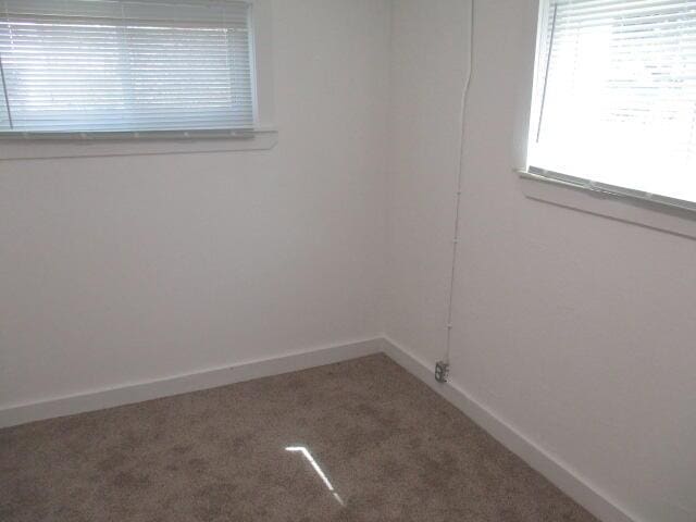 empty room featuring carpet floors and baseboards