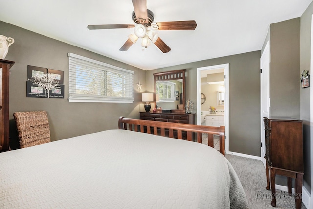 carpeted bedroom with a ceiling fan, baseboards, and ensuite bath