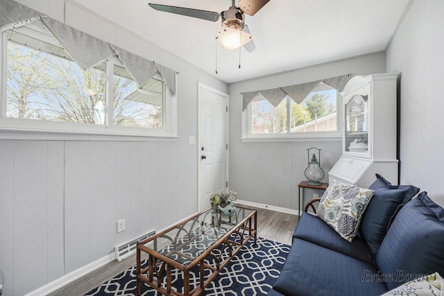living area with visible vents, baseboards, ceiling fan, and wood finished floors