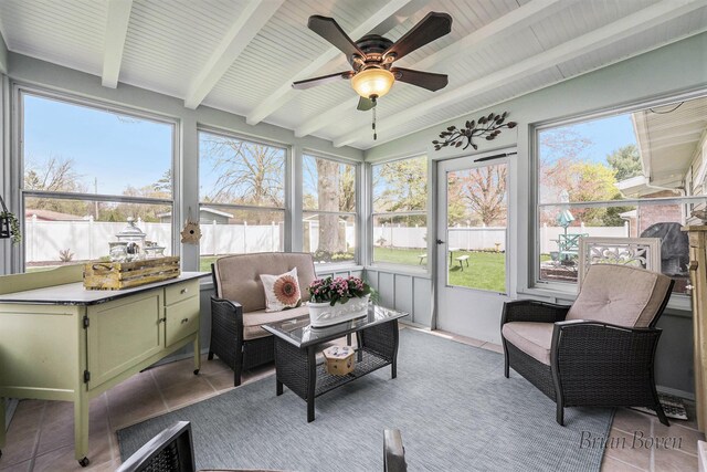sunroom / solarium featuring ceiling fan, a healthy amount of sunlight, and beam ceiling