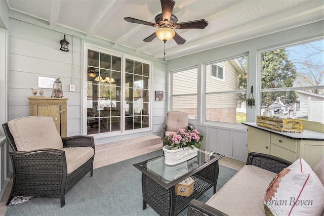 sunroom featuring beamed ceiling and a ceiling fan