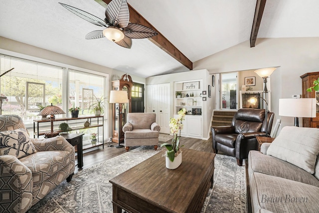 living room featuring lofted ceiling with beams, a ceiling fan, and dark wood-style flooring