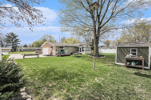 view of yard with fence, driveway, and a deck