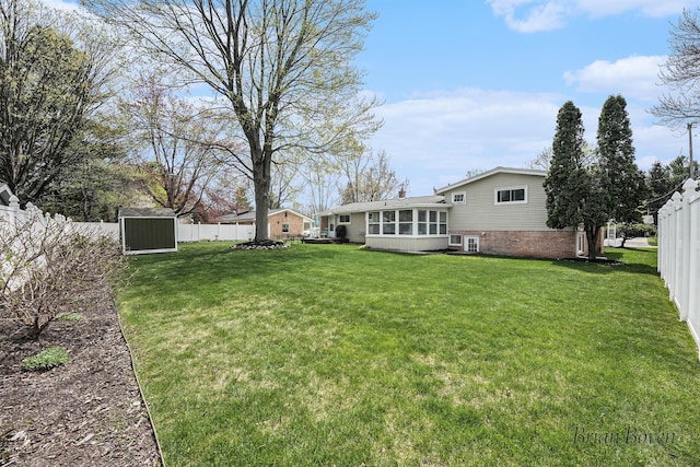 view of yard featuring a fenced backyard, an outdoor structure, and a storage shed