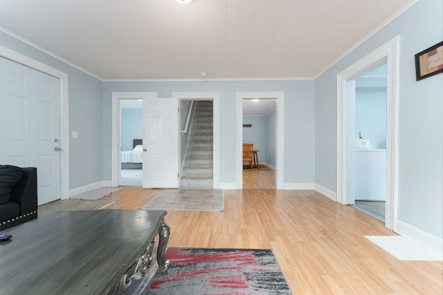 foyer with crown molding, baseboards, stairs, and wood finished floors