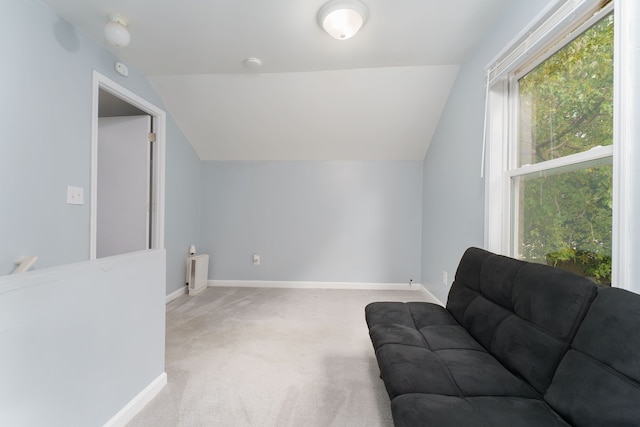 sitting room with baseboards, light colored carpet, and lofted ceiling