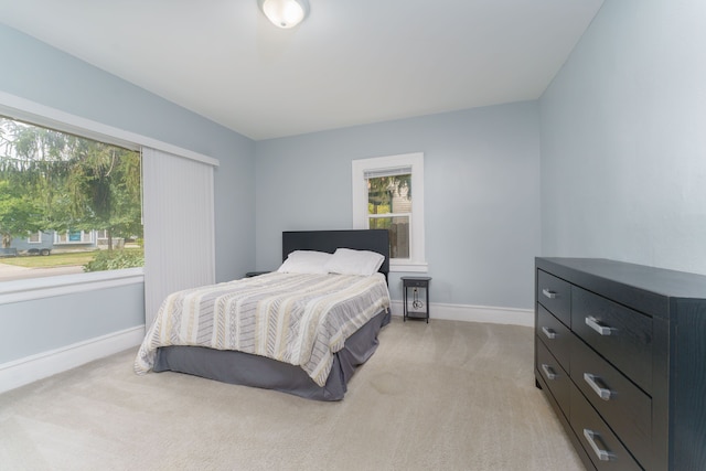 bedroom featuring baseboards and light carpet